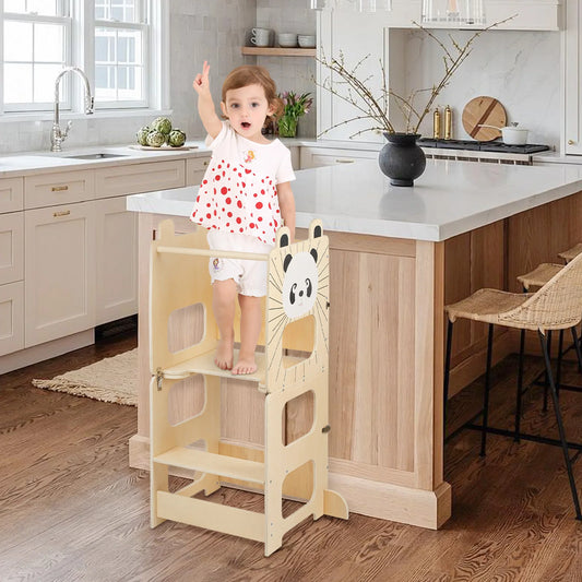Enfant sur la tour d'apprentissage à hauteur du plan de travail de la cuisine