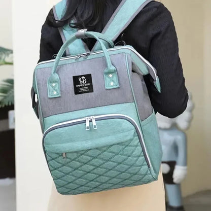 Sac à dos à langer vert d'eau porté au dos